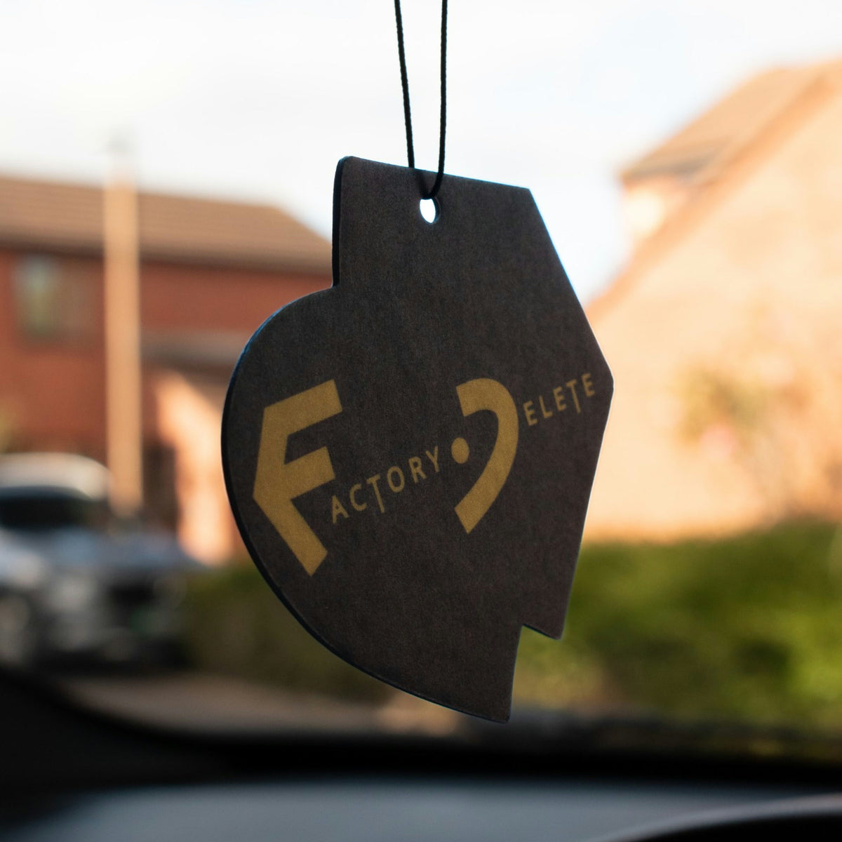 Reverse of the Factory Delete car air freshener showing the full Factory Delete logo